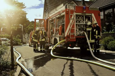 Feuerwehreinsatz mit Feuerwehrleuten und Feuerwehrfahrzeug