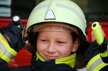 Kind in Feuerwehrschutzkleidung