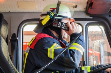 Feuerwehrmann im Einsatzfahrzeug beim funken